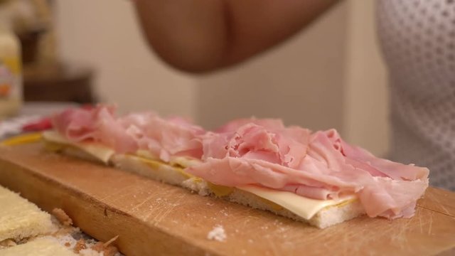 preparation of  snack. woman hands putting ham on bread. Sandwich,food,tasty