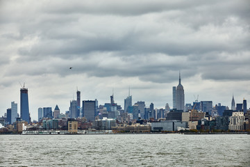 Obraz premium New York city skyline from ferry boat on the ocean, State of Liberty travel
