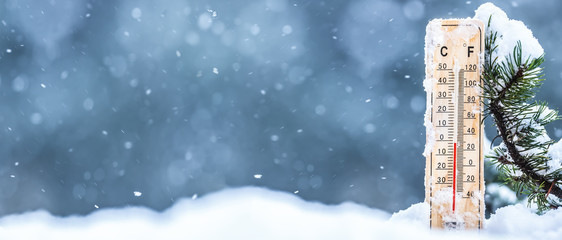 Fototapeta Thermometer on snow shows low temperatures in celsius or farenheit obraz