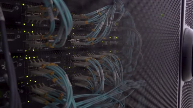 Blurred background. Severs computer in a rack at the large data center. Optical Fiber Cable Connector Activity Indicator Blinking. 