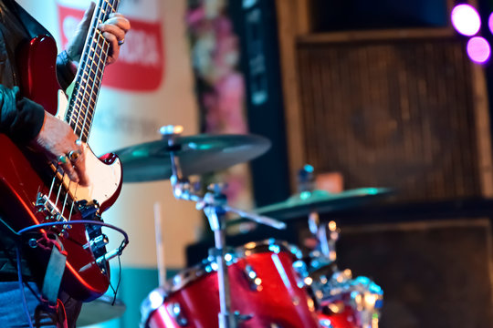 Close-up of guitarist playing guitar in live concert on stage. 