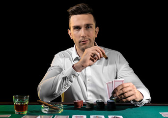 Handsome male player at table in casino