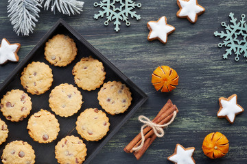 Christmas chocolate chip cookies, flat lay with spices and winter decorations on dark