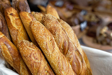 Traditional crusty French bread baguette in basket at bakery. Fresh organic pastry at local market. France cuisine background