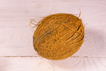 One whole coconut on a wooden table. Top view