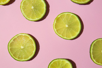 Many slices of lime on color background