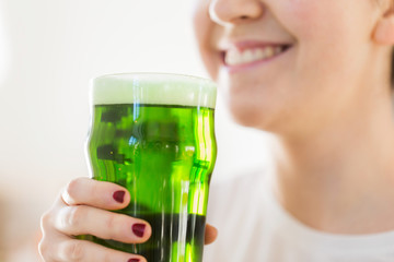 alcohol and st patricks day concept - close up of woman with green beer in glass