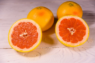 Ripe juicy grapefruit on a white wooden table