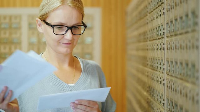 Portrait of a young stylish woman with a bundle of letters in her hands in the post office