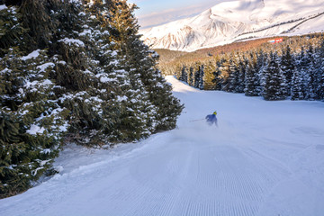 Skier running down the slope in Karakol mountains. Beautiful sunny day ski closeup.