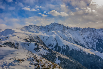 Scenic alpine landscape with and mountain ranges. forest and snow-capped mountain tops in the background. National park of Kyrgyzstan. Nice view.