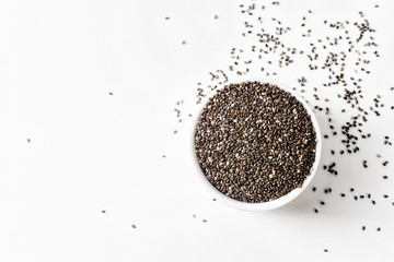 Black raw chia sseds on white background. Superfood, healthy lifestyle ingredient concept