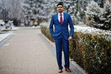 Elegant indian fashionable man model on suit posed at winter day.