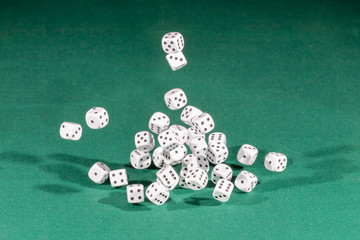 Thirty white dices falling on a green table