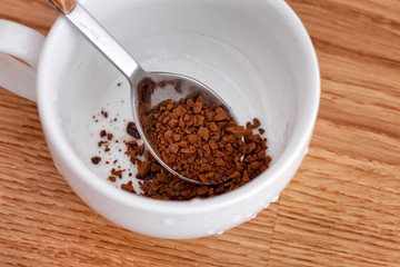 Spoon with instant coffee inside of a cup
