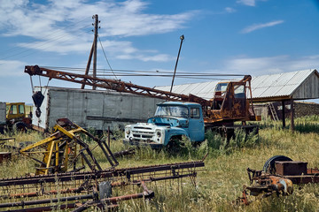 The old Soviet auto and agricultural machinery abandoned in the steppe not far from Sartymbet village, stone mountains "Monasteries" and "Aiyrtau", near the town of Ust-Kamenogorsk in East Kazakhstan