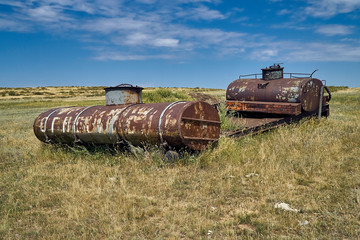 The old Soviet auto and agricultural machinery abandoned in the steppe not far from Sartymbet village, stone mountains "Monasteries" and "Aiyrtau", near the town of Ust-Kamenogorsk in East Kazakhstan