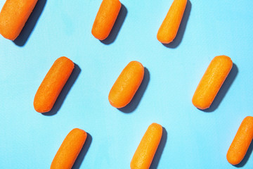 Many baby carrots on color background