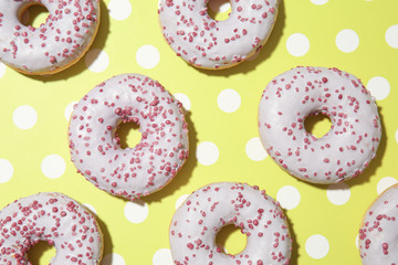 Many tasty doughnuts on color background