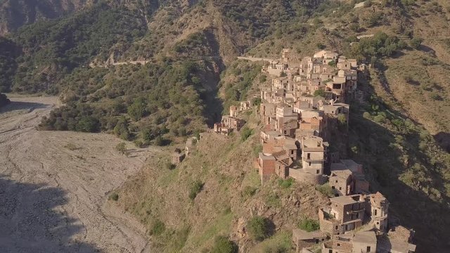 Stunning 4k backwards aerial over abandoned ghost town of Roghudi, Italy