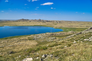 Fototapeta na wymiar Beautiful summer steppe landscape and Ayr (Monastyri) Lake, located in stone mountains 