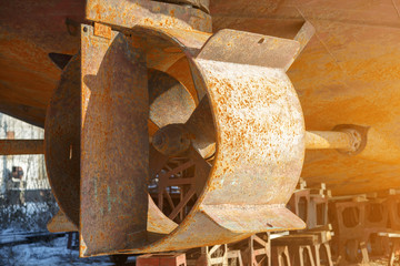 Rusty screw in the nozzle, the rudder and shaft of the ship, standing in a dry dock during the repair