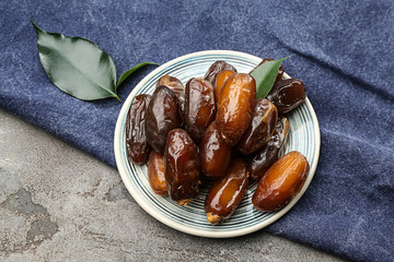Plate with sweet dried dates on table