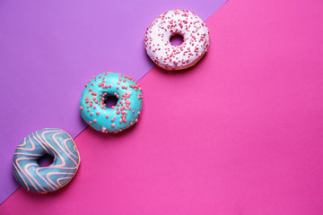 Sweet tasty donuts on color background