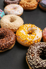 Sweet tasty donuts on dark background