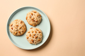 Plate with tasty cookies on color background