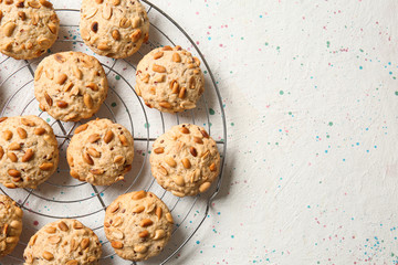 Cooling rack with tasty cookies on light background