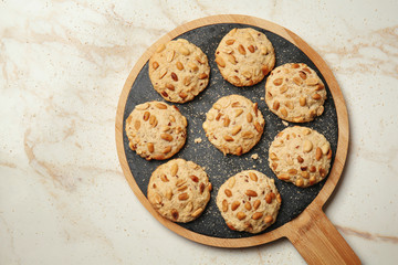 Board with tasty cookies on light background