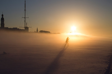 силуэт лыжника на золотом фоне заходящего солнца