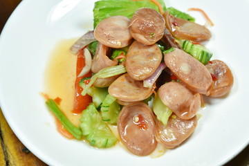 spicy Chinese pork sausage with vegetable Thai salad on plate