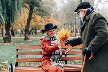 Obraz na płótnie Canvas Surprised retired female person taking autumn bouquet