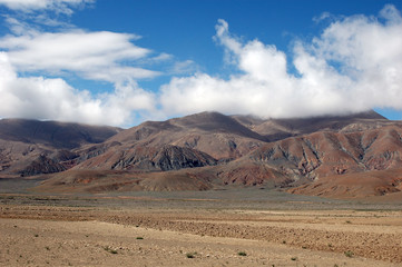 Fototapeta na wymiar Brown mountains, blue sky and clouds in tibet