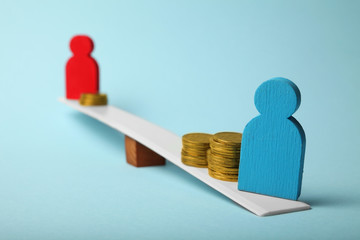 Inequality in level of pay. People income gap. Coins on scales.