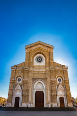 Fototapeta na wymiar Cathedral of San Pietro Apostolo, also known as Duomo Tonti, by Paolo Tonti, who donated his wealth for its construction. Facade with rose windows and portals. Cerignola, Puglia, Italy.