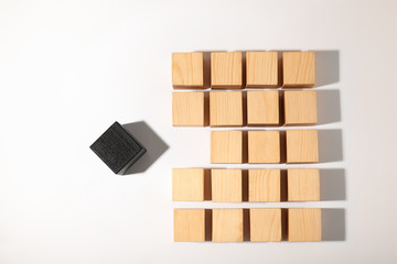 One different cube standing out from others on white background, top view