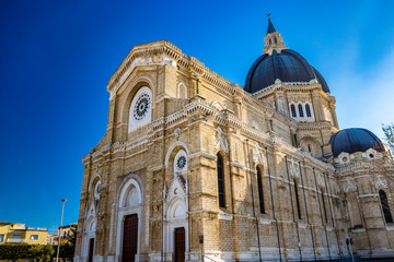 Fototapeta na wymiar Cathedral of San Pietro Apostolo, also known as Duomo Tonti, by Paolo Tonti, who donated his wealth for its construction. Facade, rose windows, portals, dome and apse. Cerignola, Puglia, Italy.