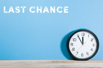 Last chance words on blue colored background with clock