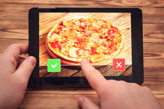 Pizza order with tablet pc. Screen with buttons and finger selecting apply or decline item.