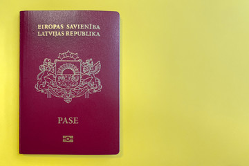 Passport of Latvia on a yellow background (copy space)