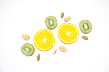 sliced orange and kiwi and almond and pistachio on white background 