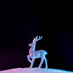 Obraz na płótnie Canvas Santas reindeer on snow in vibrant bold gradient holographic colors. Christmas concept art. Minimal New Year surrealism.
