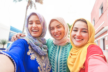 Jeunes amis islamiques prenant un selfie avec un appareil photo pour smartphone en plein air