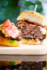 Hamburgers and French fries on the wooden tray.