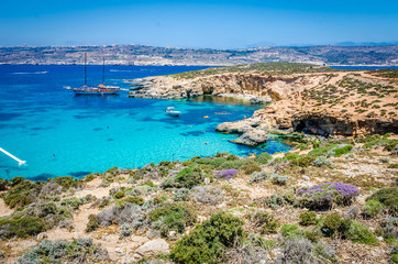 Fototapeta premium Blue Lagoon, Malta - the caves of the Blue Lagoon on the island of Comino on a bright sunny summer day with blue sky