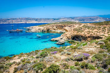 Blue Lagoon, Malta - the caves of the Blue Lagoon on the island of Comino on a bright sunny summer day with blue sky