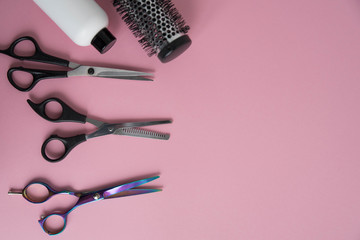 Professional hair dresser tools on pink background with copy space. Hair stylist equipment set....